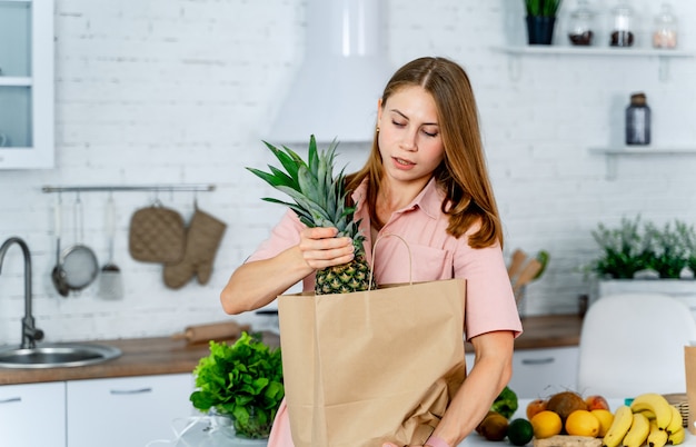 Mulher com o pacote de supermercado nas mãos.