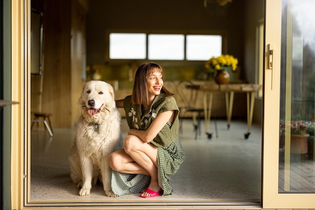 Mulher com o seu cão bonito em casa