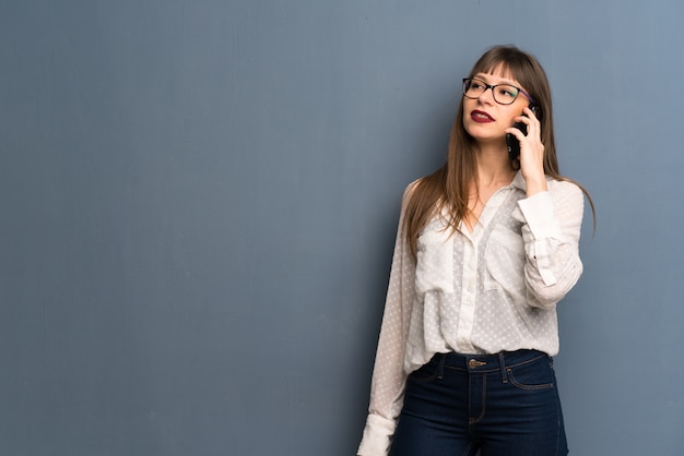 Mulher, com, óculos, mantendo uma conversa, com, a, telefone móvel