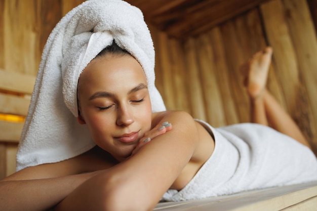 Mulher com os olhos fechados curtindo a sauna