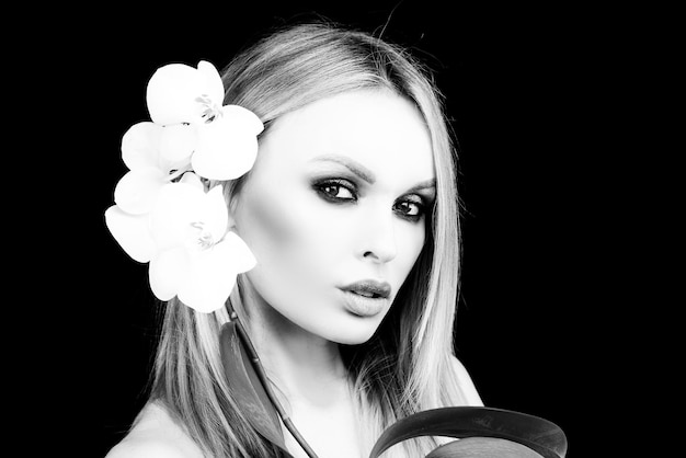 Mulher com produtos cosméticos de flores de orquídea beleza cuidados de saúde