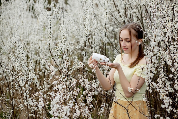 Mulher com remédio nas mãos Fighting Spring Allergies Outdoor - Retrato de uma mulher alérgica cercada por flores sazonais