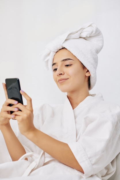 Foto mulher com roupão de banho tirando selfie