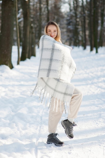 Mulher com roupas de inverno em parque nevado
