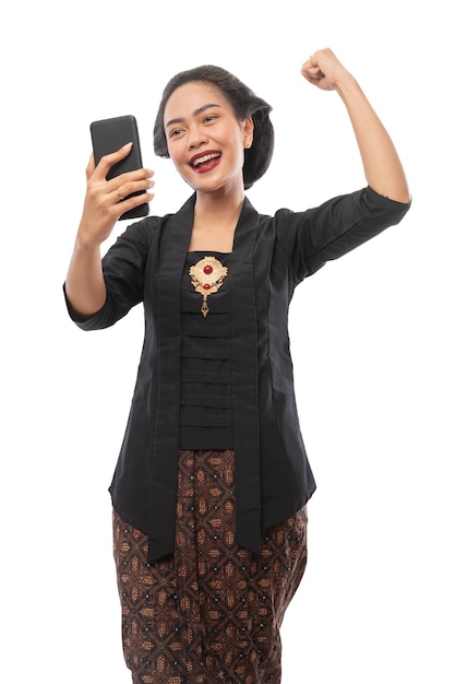Mulher com roupas kebaya feliz olhando para o telefone