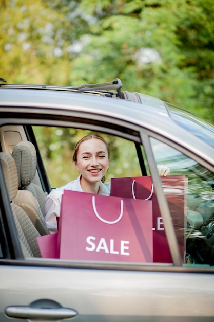 Mulher com sacos de compras no conceito de compras de carro