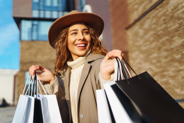 Mulher com sacos de compras perto do centro comercial Consumismo compras compras conceito de venda de estilo de vida