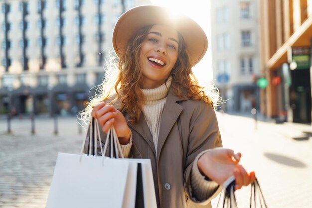 Mulher com sacos de compras perto do centro comercial Consumismo compras compras conceito de venda de estilo de vida