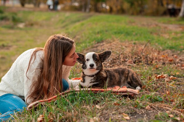 Mulher com seu cachorro nas folhas de outono