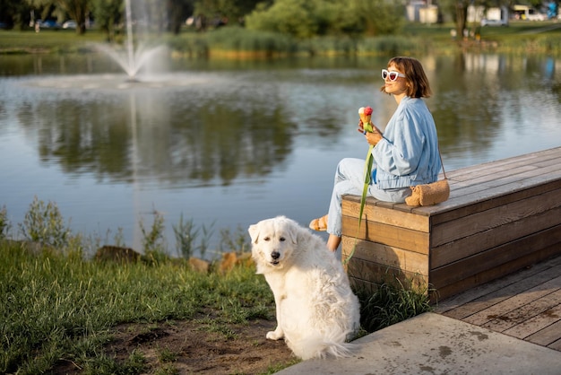 Mulher com seu cachorro perto do lago no parque