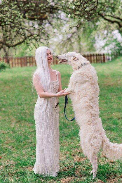 Mulher com seu cão wolfhound russo no jardim