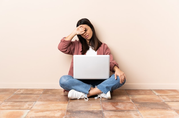 Mulher com seu laptop sentada no chão