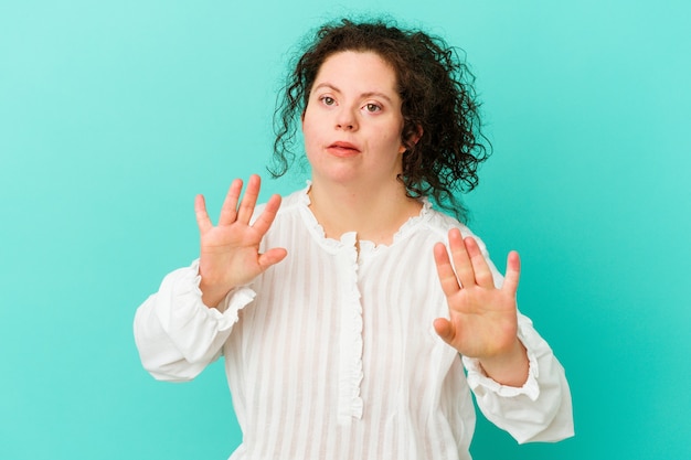 Mulher com síndrome de Down isolada rejeitando alguém com um gesto de nojo.