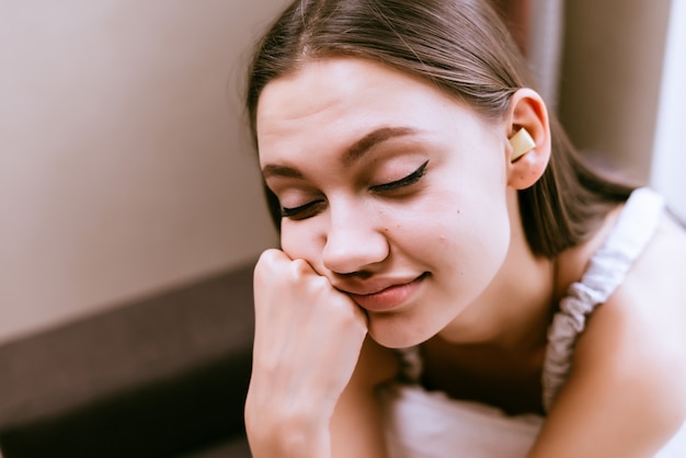 Mulher com sono sentada na cama com os olhos fechados na cama