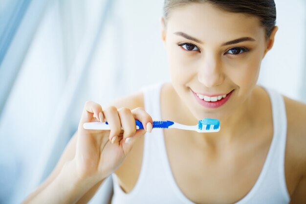 Mulher com sorriso lindo, saudáveis dentes brancos com escova de dentes