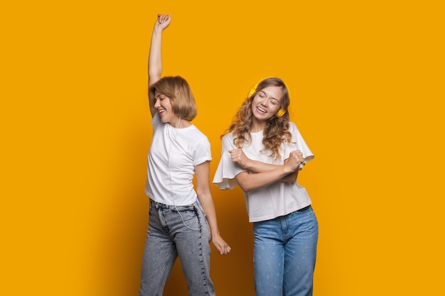 Mulher com sua amiga está ouvindo música e dançando