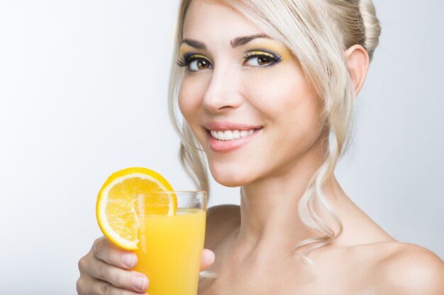 Mulher com suco de laranja na mão