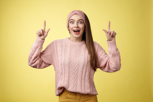 Mulher com suéter rosa sobre amarelo