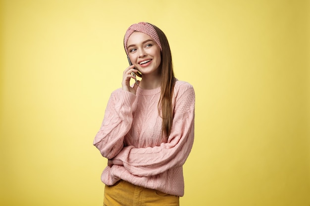 Mulher com suéter rosa sobre amarelo