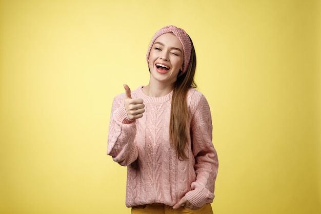 Mulher com suéter rosa sobre amarelo