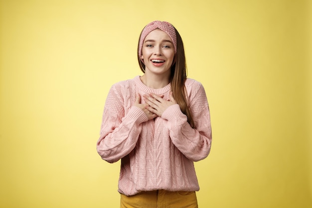 Mulher com suéter rosa sobre amarelo