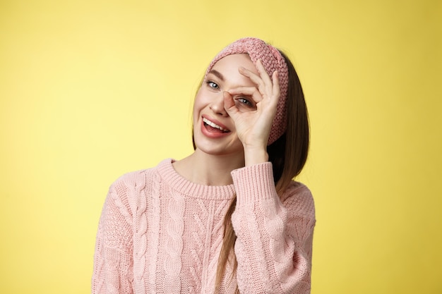 Mulher com suéter rosa sobre amarelo