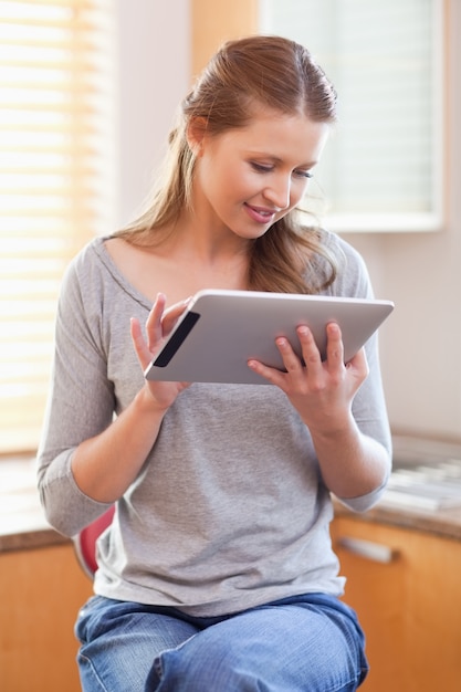 Mulher com tablet na cozinha