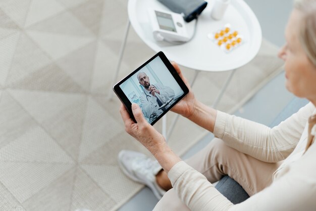 Mulher com tablet pc durante uma consulta online com seu médico