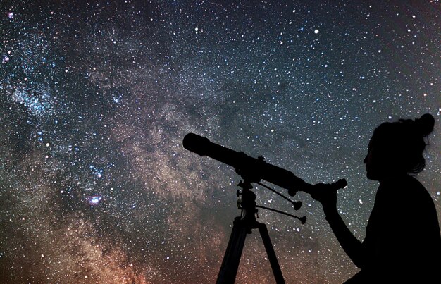 Foto mulher com telescópio observando as estrelas observando o céu noturno