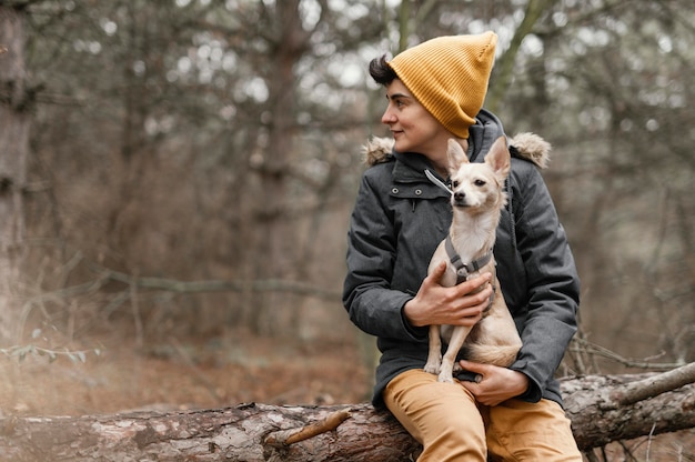 Mulher com tiro médio segurando cachorro