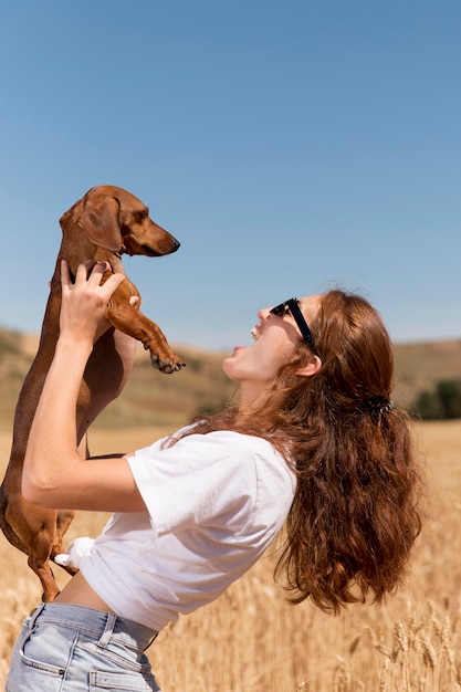 Foto mulher com tiro médio segurando um cachorro