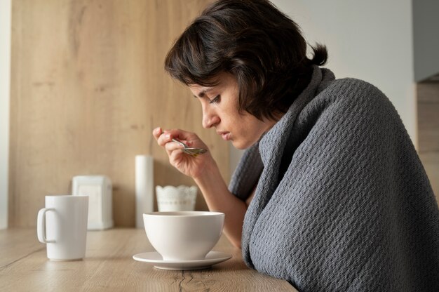 Foto mulher com tiro médio tomando sopa