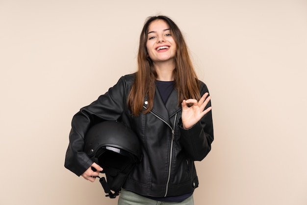 Mulher com um capacete de moto isolado em bege