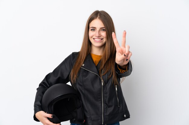 Mulher com um capacete de moto sorrindo e mostrando sinal de vitória