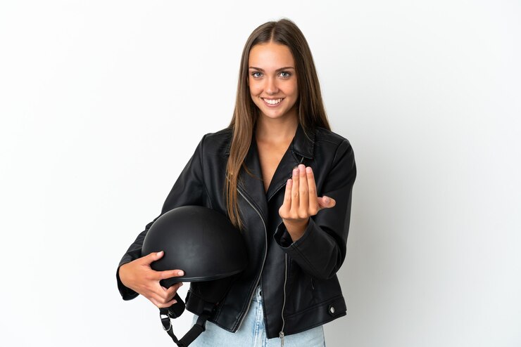 Foto mulher com um capacete de motocicleta sobre fundo branco isolado, convidando a vir com a mão. feliz que você veio