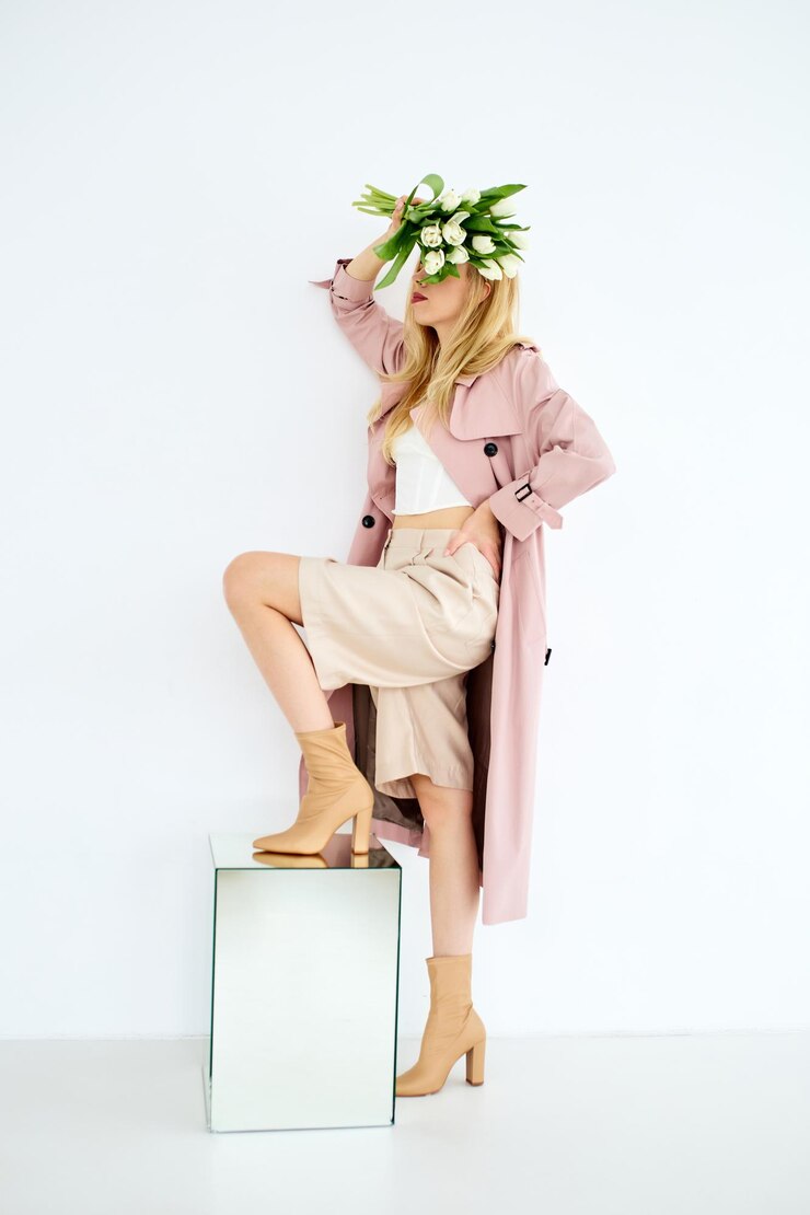 Foto mulher com um elegante casaco de trincheira posa com um buquê de flores