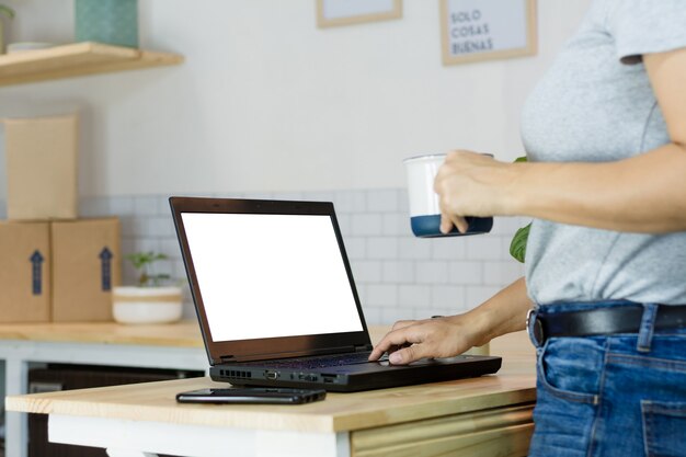 Mulher com um laptop e uma xícara de café
