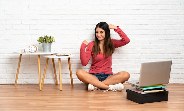 Mulher com um laptop sentada no chão