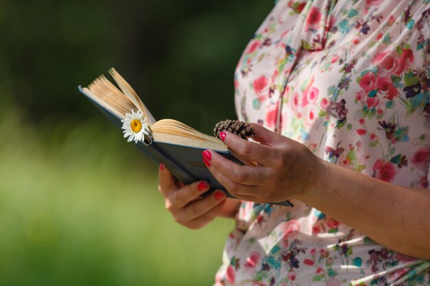 Mulher com um livro na floresta de verão