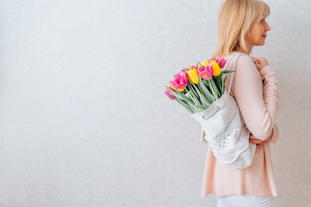 Mulher com um saco de flores de tulipas