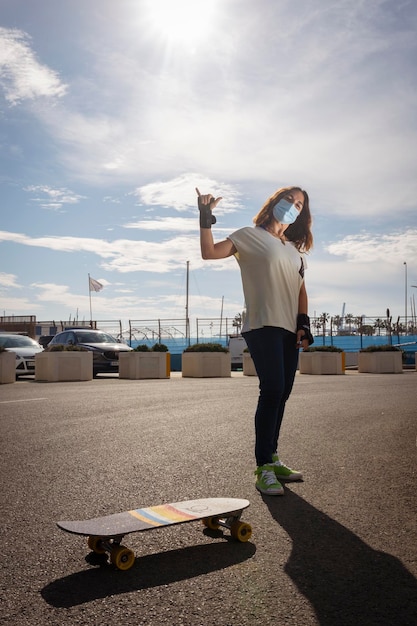 Mulher com um skate cumprimenta a câmera