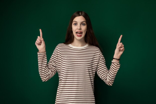 Mulher com uma camisa listrada segurando dois dedos para cima