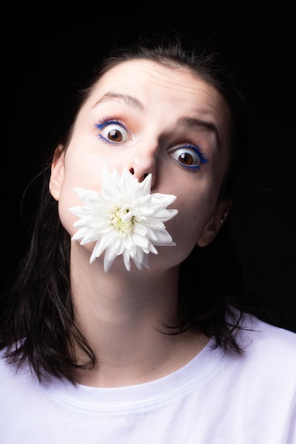 mulher com uma flor branca na boca