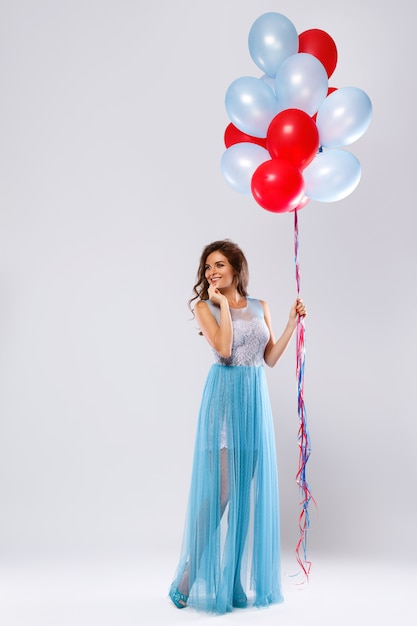 Mulher com vestido bonito com muitos balões coloridos
