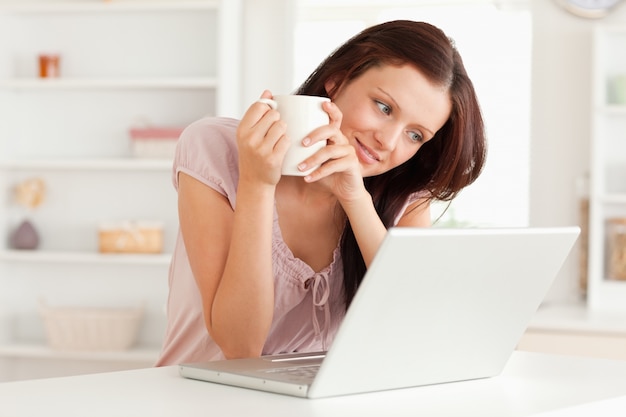 Mulher com xícara de café e laptop