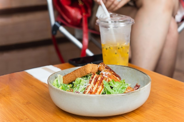 Mulher come salada caesar de comida saudável e suco de frutas no restaurante