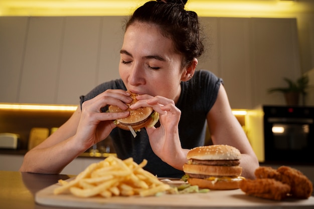 Foto mulher comendo alimentos não saudáveis à noite