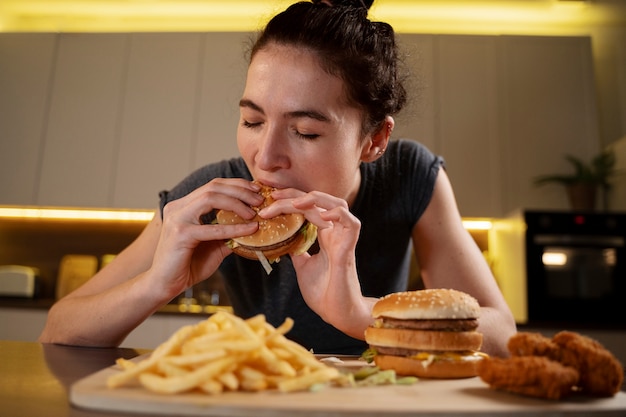 Mulher comendo alimentos não saudáveis à noite