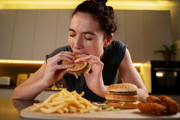 Foto mulher comendo alimentos não saudáveis à noite