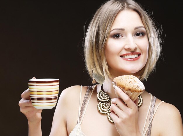 Mulher comendo biscoito e tomando café